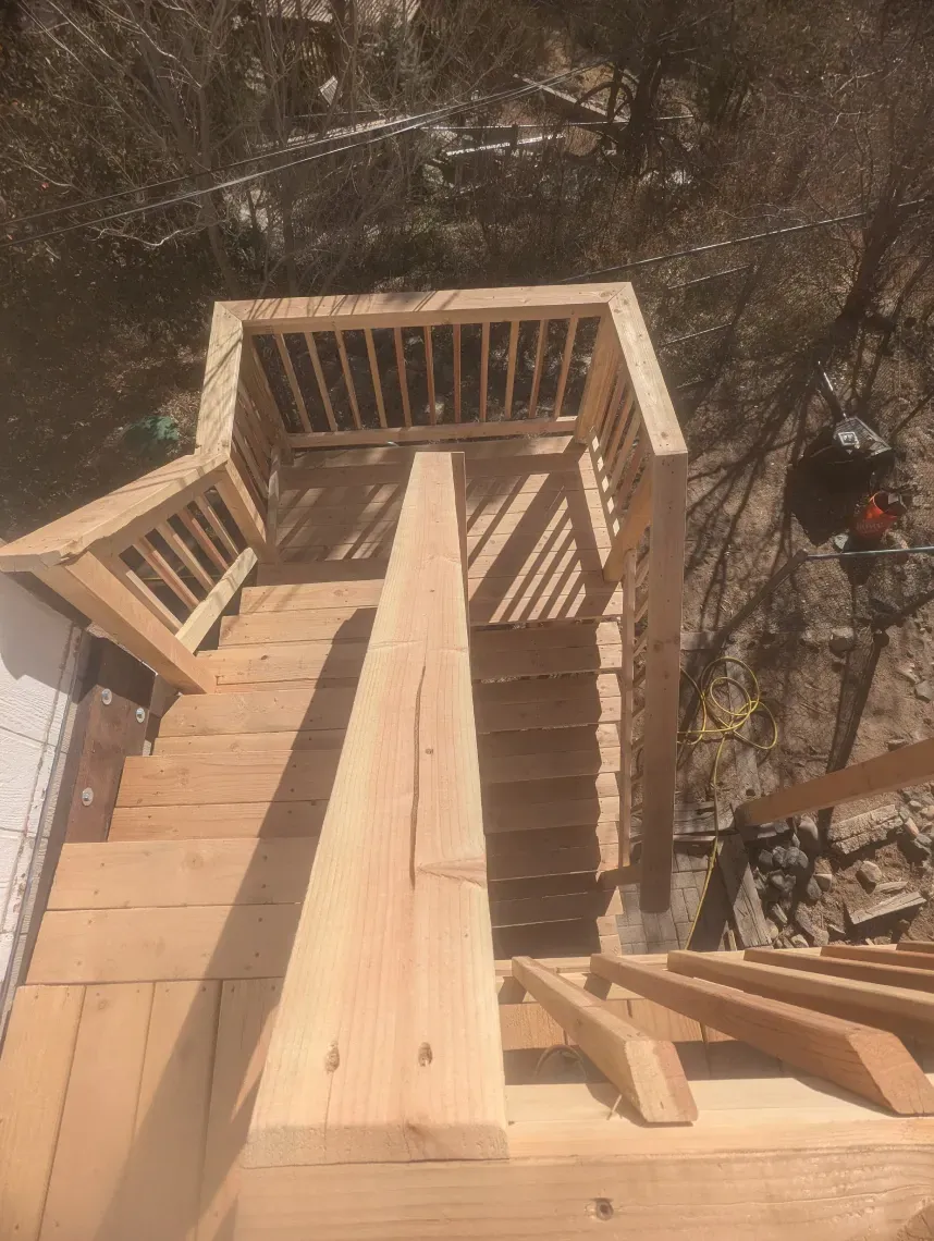 A wooden deck with stairs leading up to it is being built.