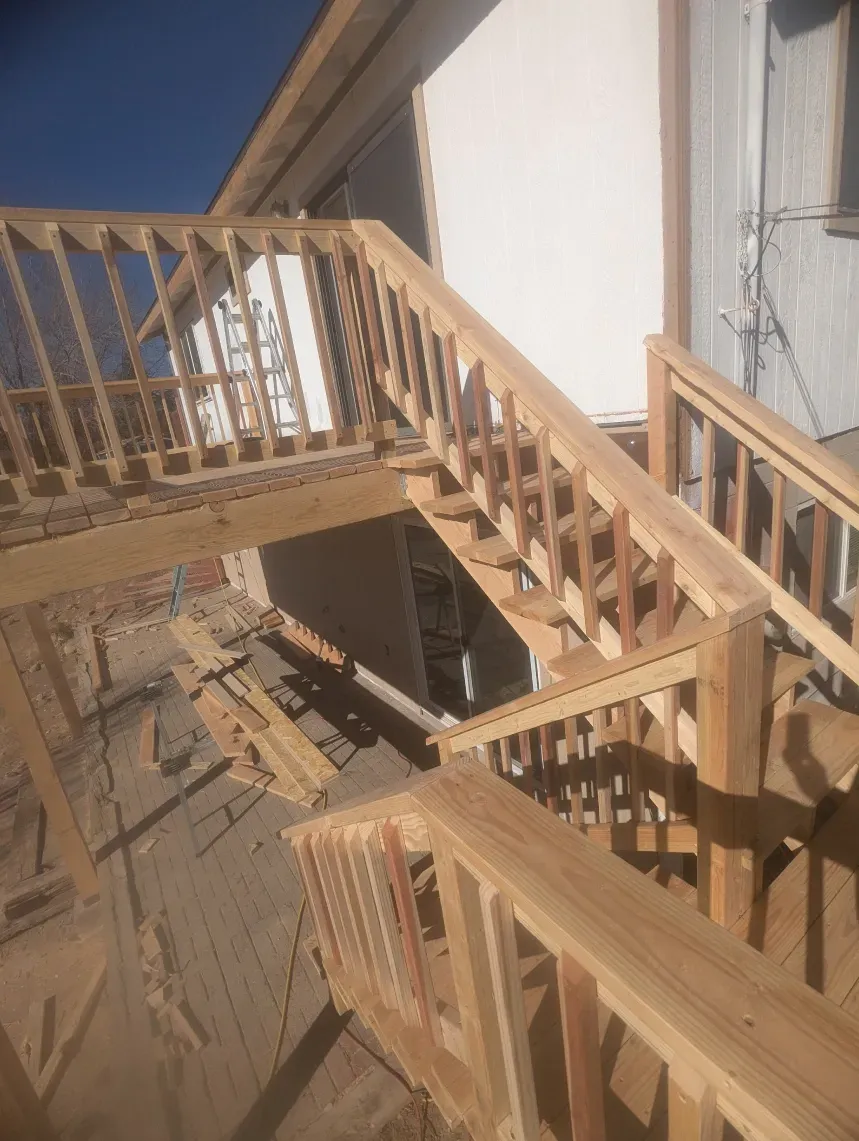 A wooden staircase is being built in front of a house.