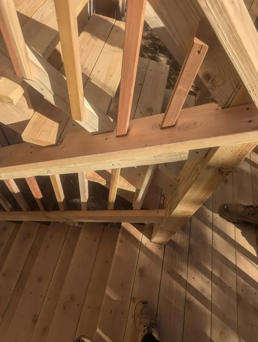 A wooden staircase is being built in a house.