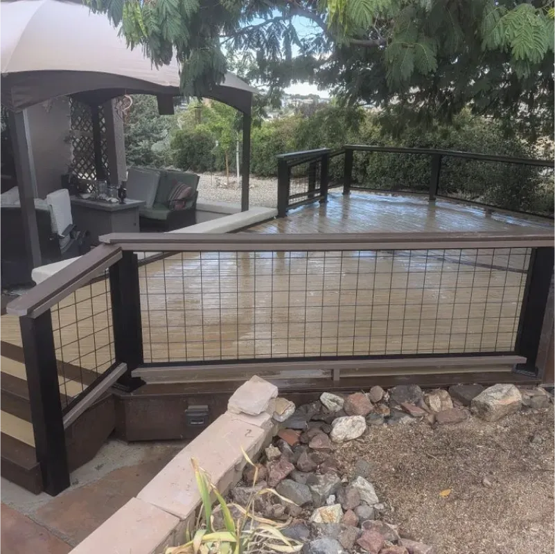 A deck with a fence and stairs leading up to it
