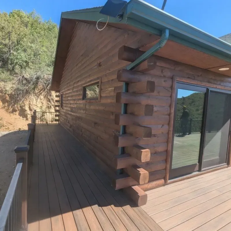 A log cabin with a deck and sliding glass doors