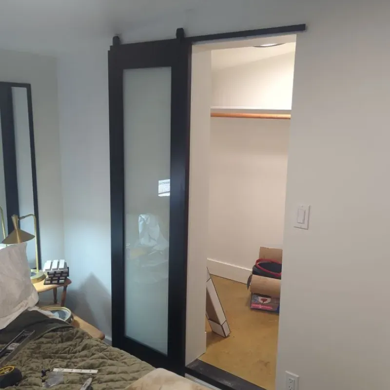 A bedroom with a sliding glass door leading to a walk in closet