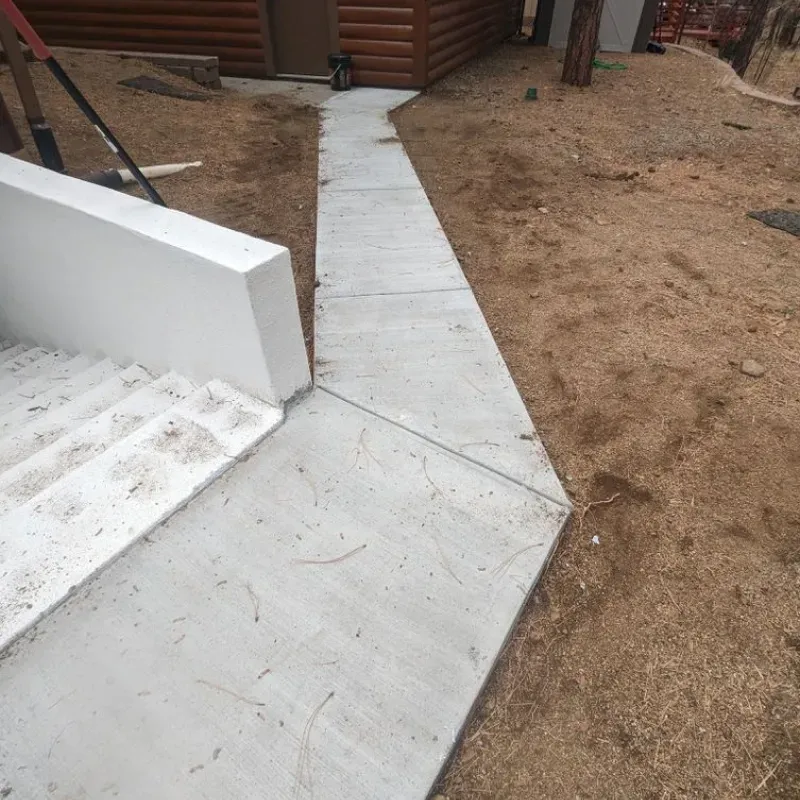 A concrete walkway next to a set of stairs