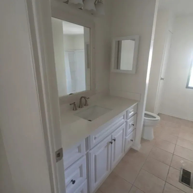 A bathroom with a sink , mirror and toilet