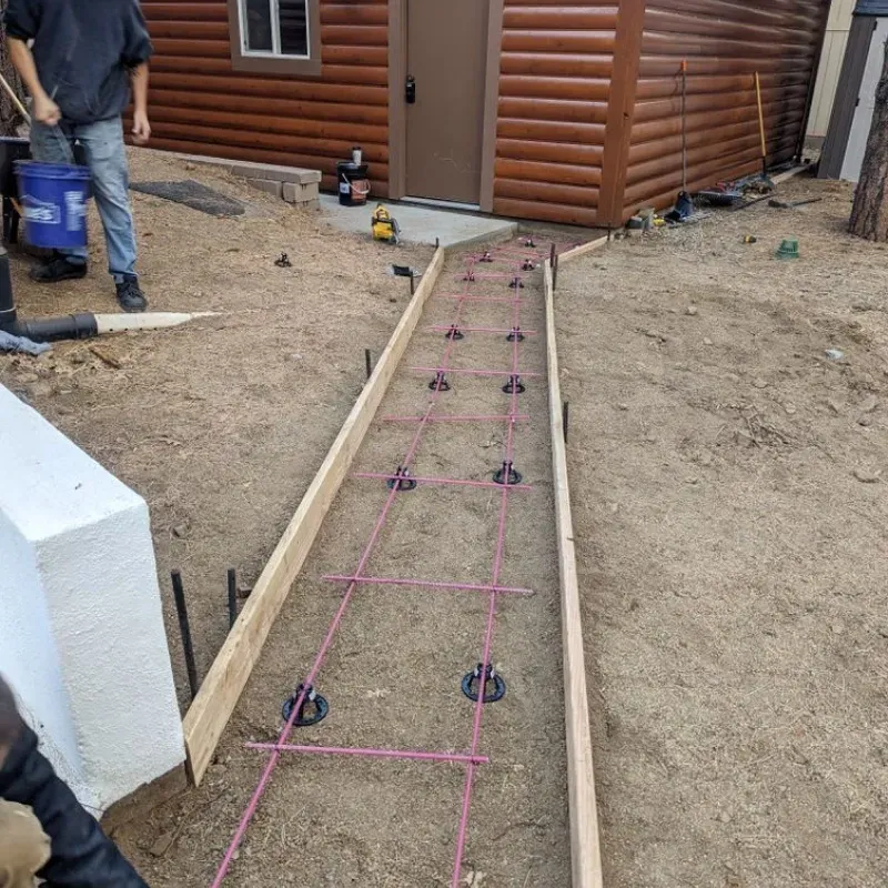 A wooden walkway is being built in front of a log cabin