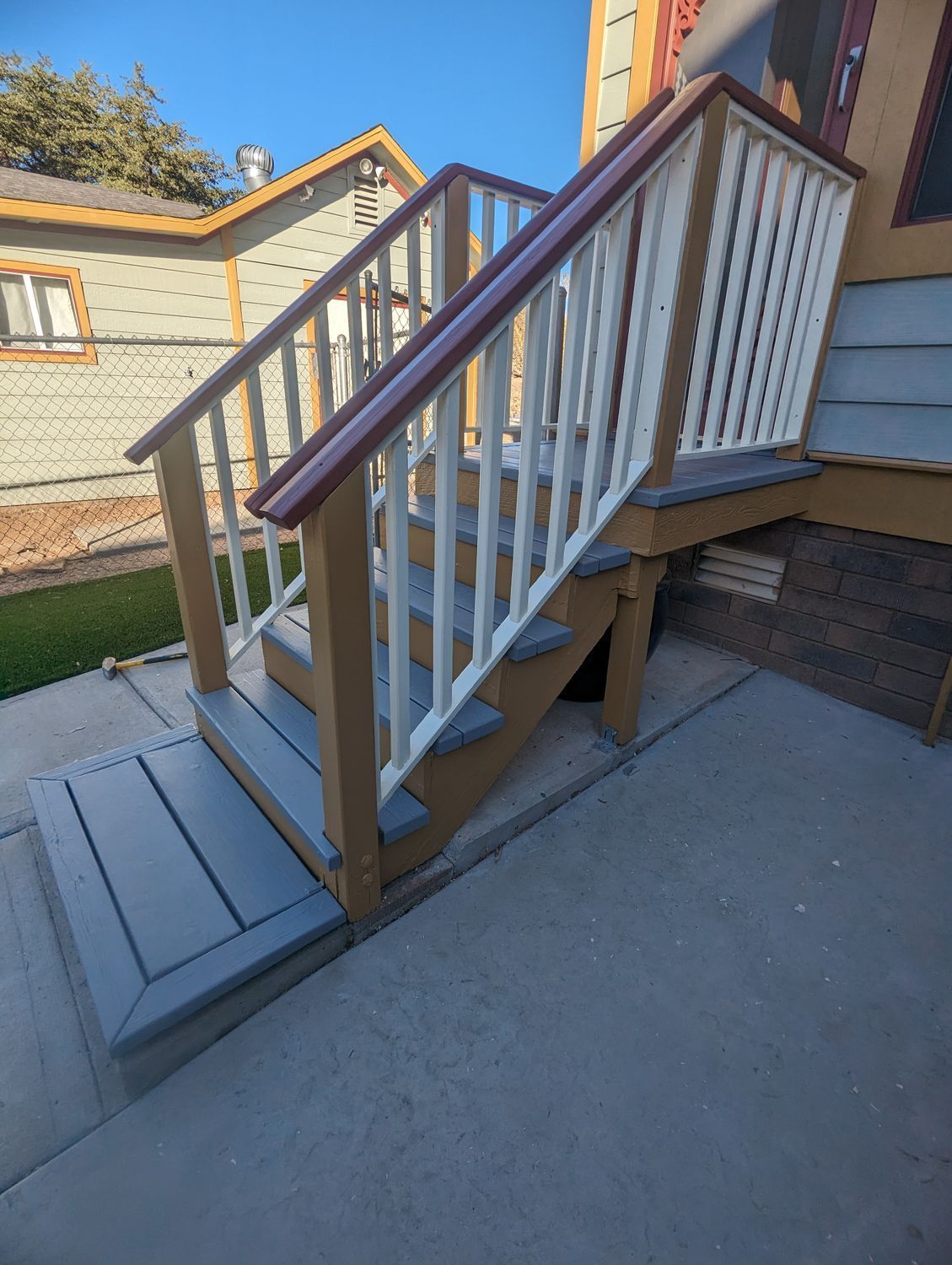 A set of stairs leading up to a house with a white railing