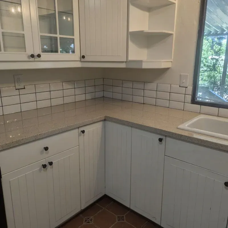 A kitchen with white cabinets and granite counter tops