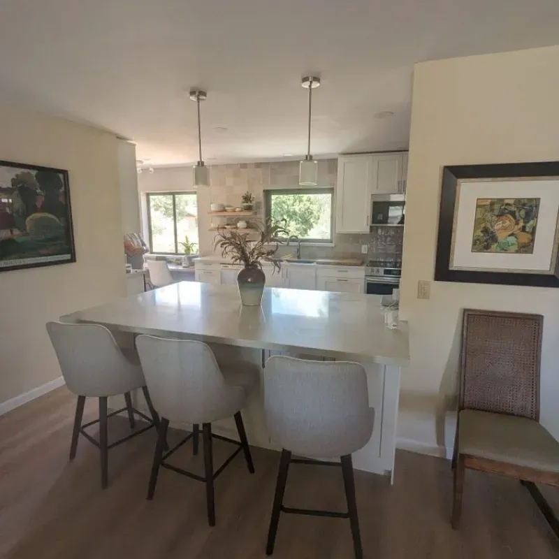 A kitchen with a table and chairs and a picture on the wall