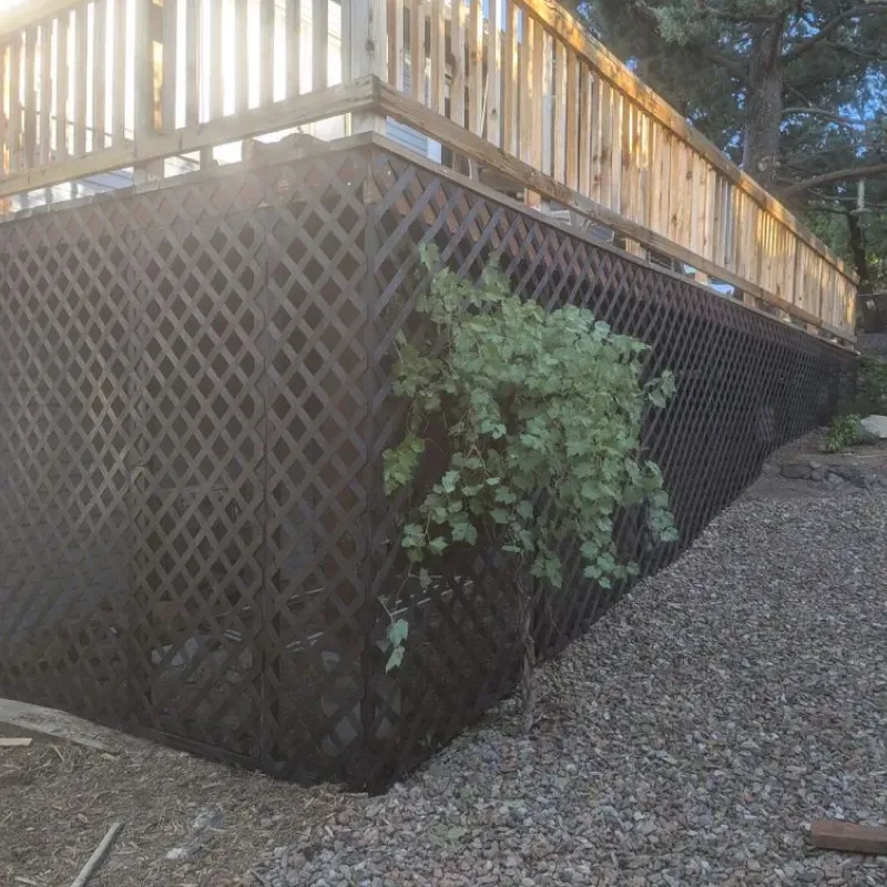 A wooden deck with a lattice fence surrounding it