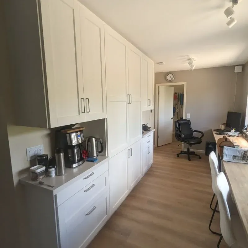 A kitchen with white cabinets and a coffee maker