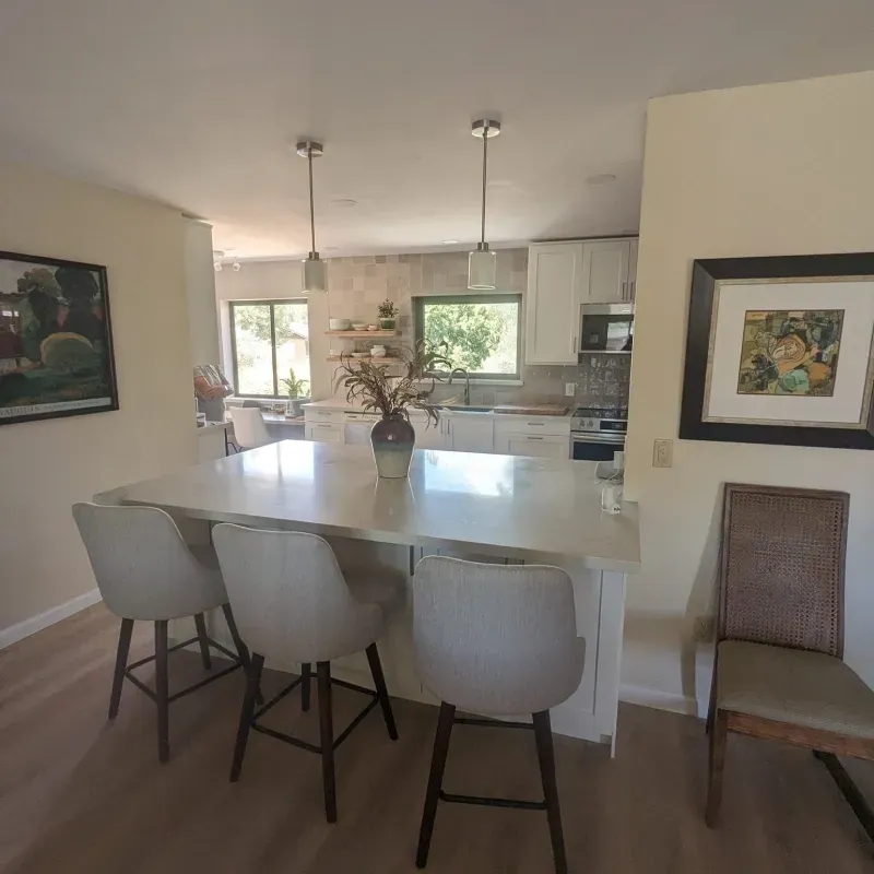 A kitchen with a table and chairs and a picture on the wall