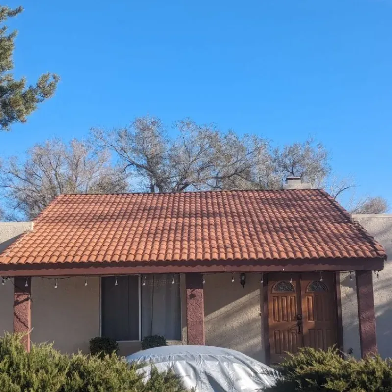 A house with a red tile roof and a car cover in front of it