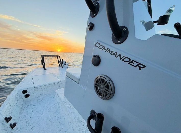 New 2026 Freedom Commander shallow water fishing boat at sunset with ocean horizon
