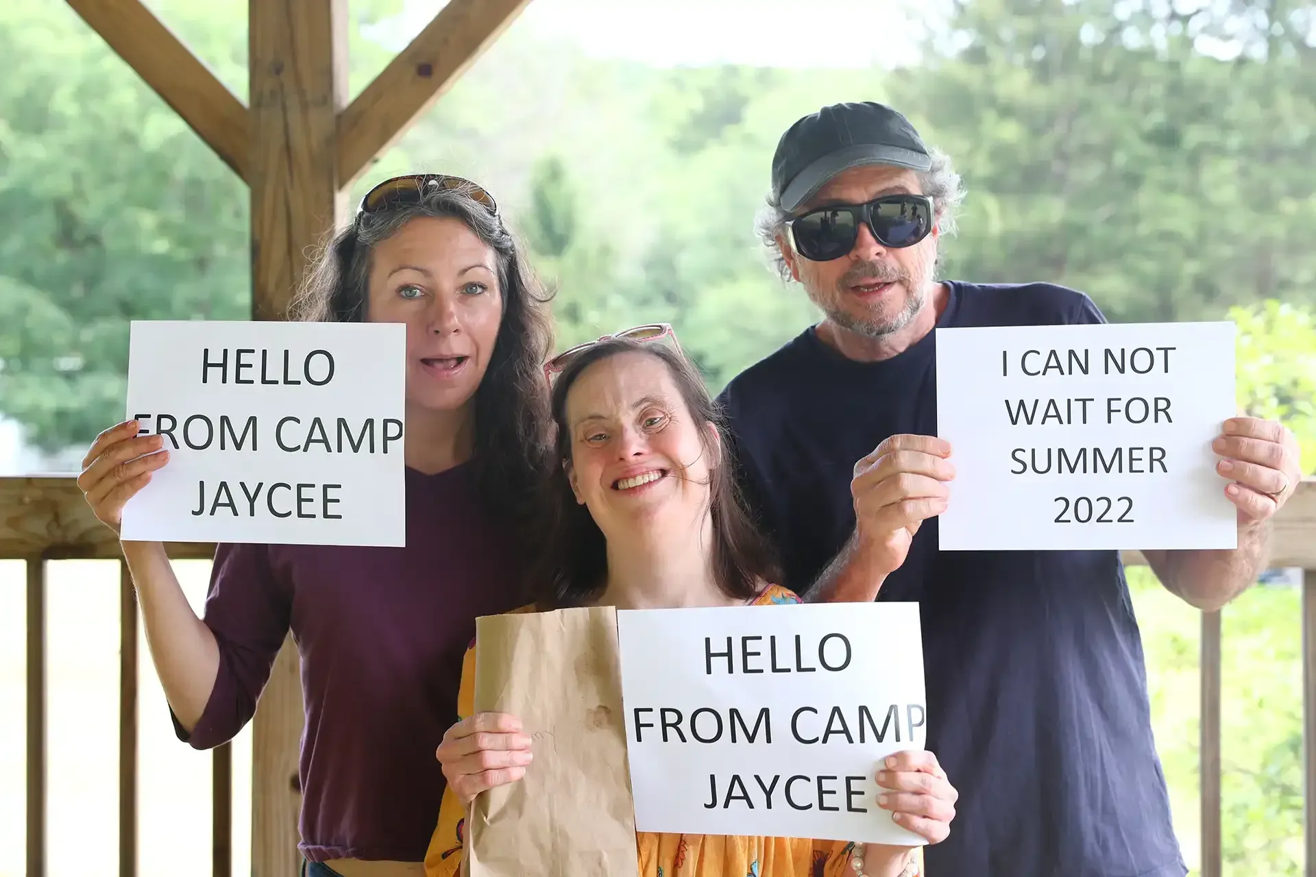 Three people holding signs that say 