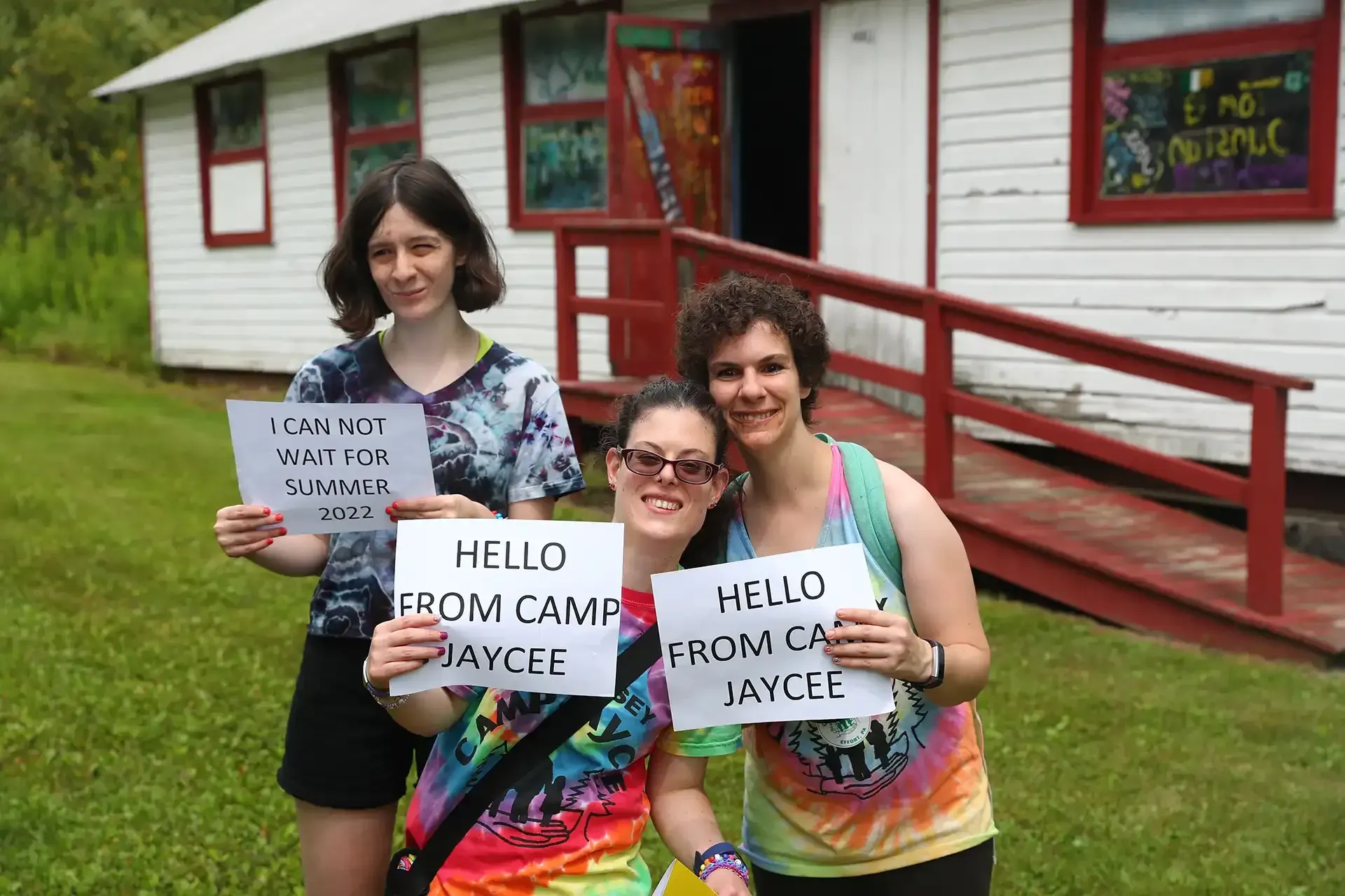 Three people holding signs that say 