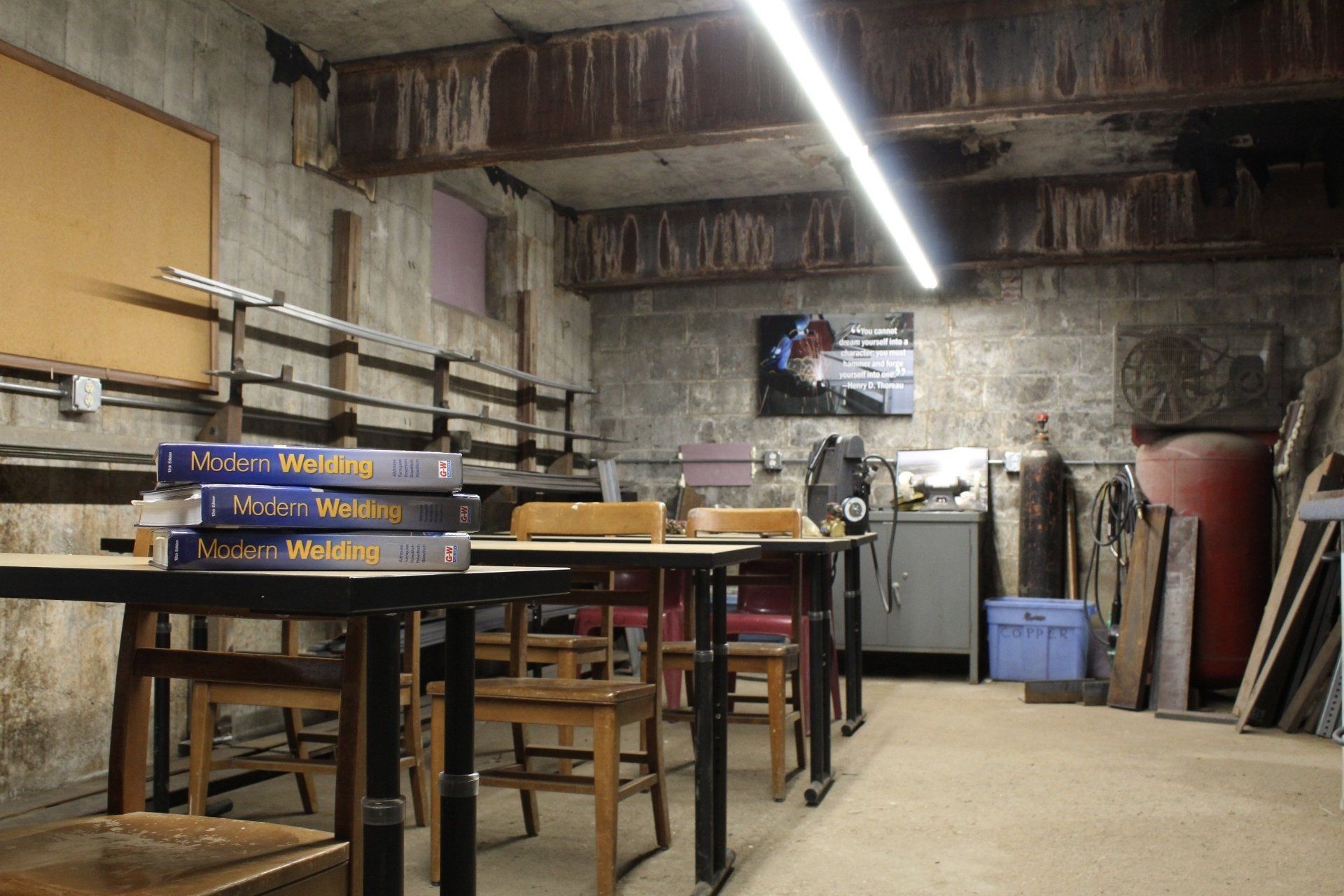 Workshop interior with workbenches, tools, and a long fluorescent ceiling light