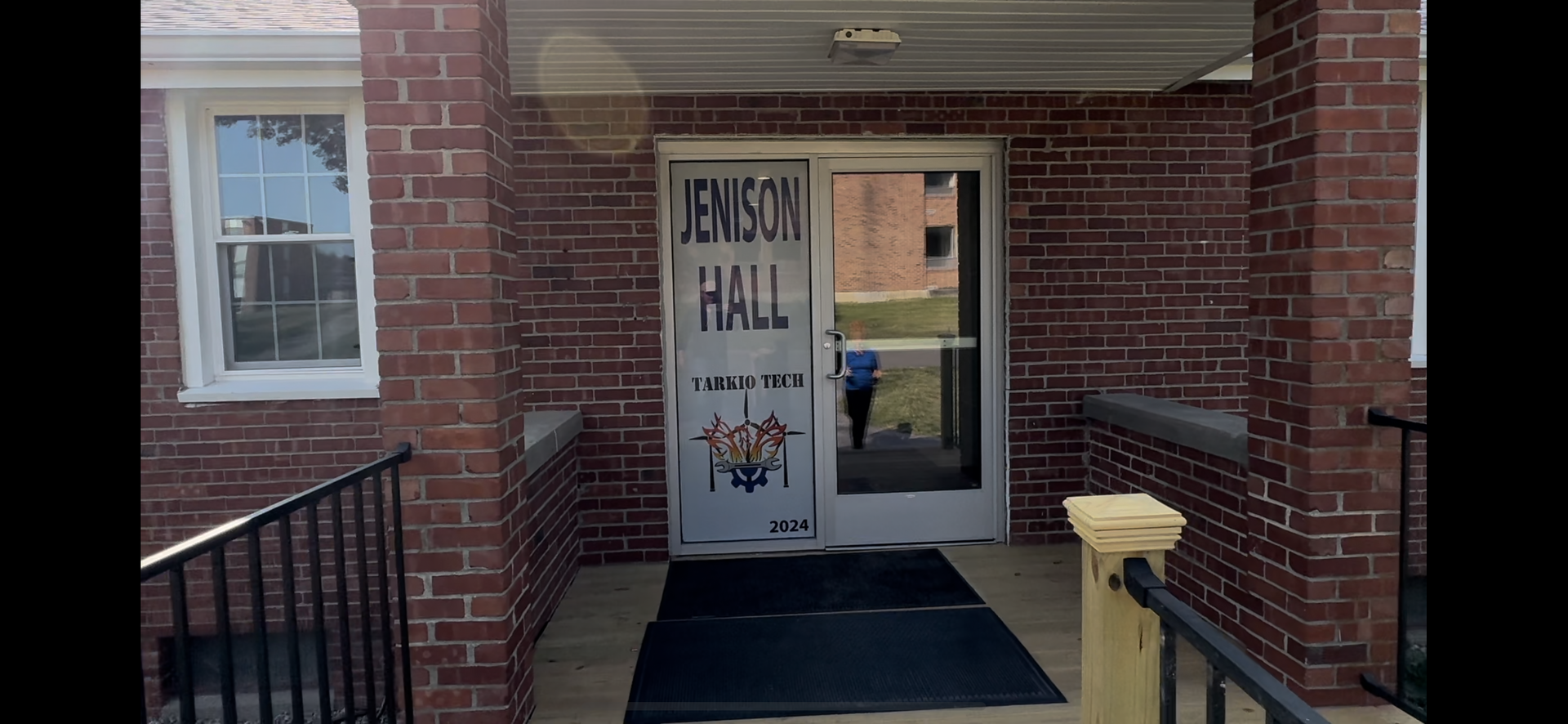Front entrance to a brick building with a door marked “Hensel Hall” and a ramp leading up to it