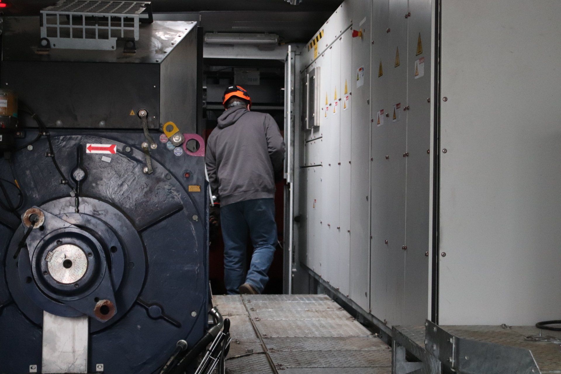 A man is standing in a room with a large machine.