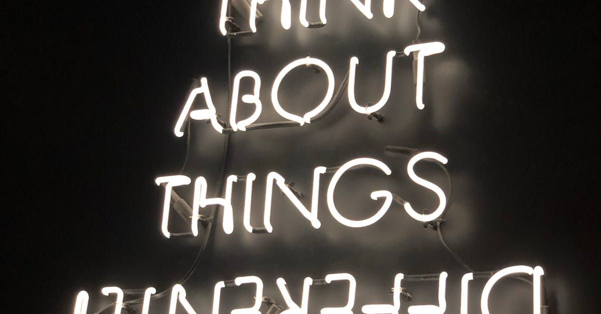 Neon sign reading “THINK ABOUT THINGS” on a dark background, shown upside down at the bottom.