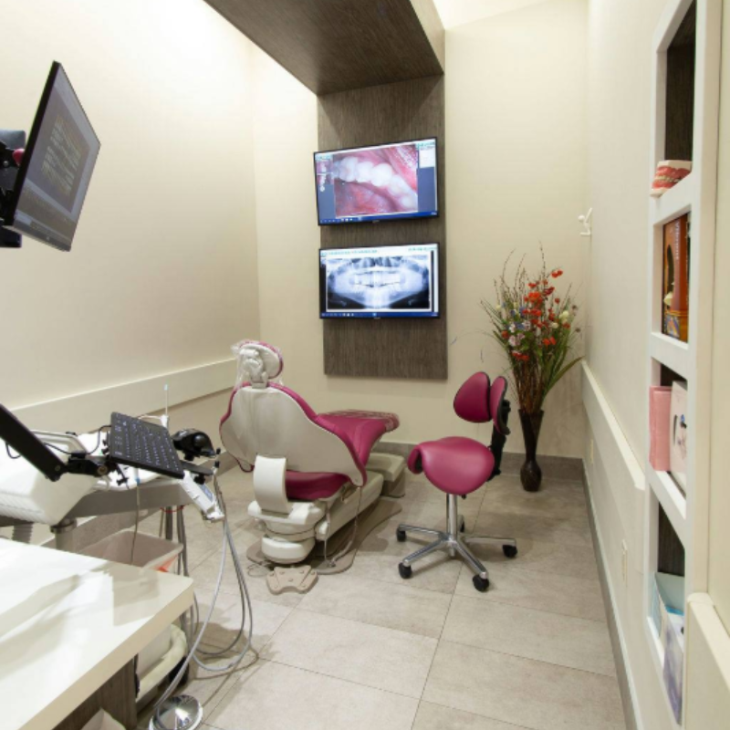 A man is sitting in a dental chair and smiling.