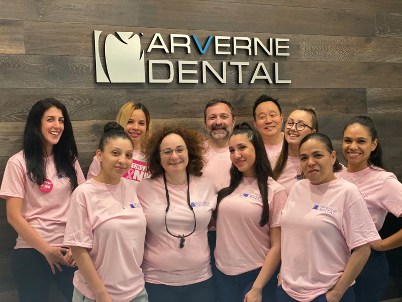 A group of people wearing pink shirts are posing for a picture.