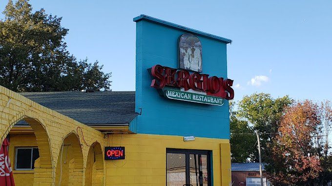 A yellow and blue building with a sign that says `` scorpions '' on it.