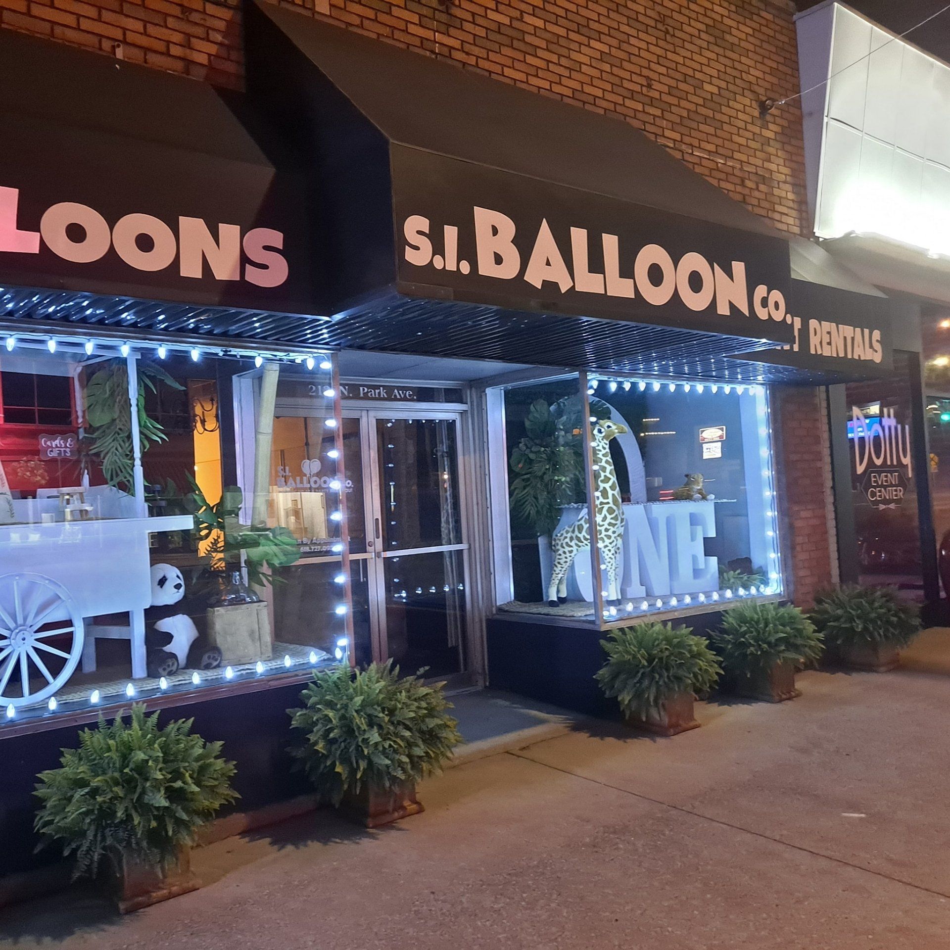 A store front with a sign that says balloons