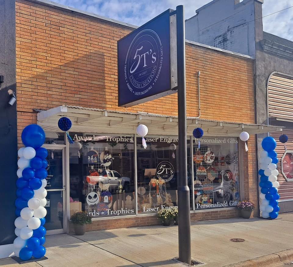 A store front with balloons and a sign that says it 's