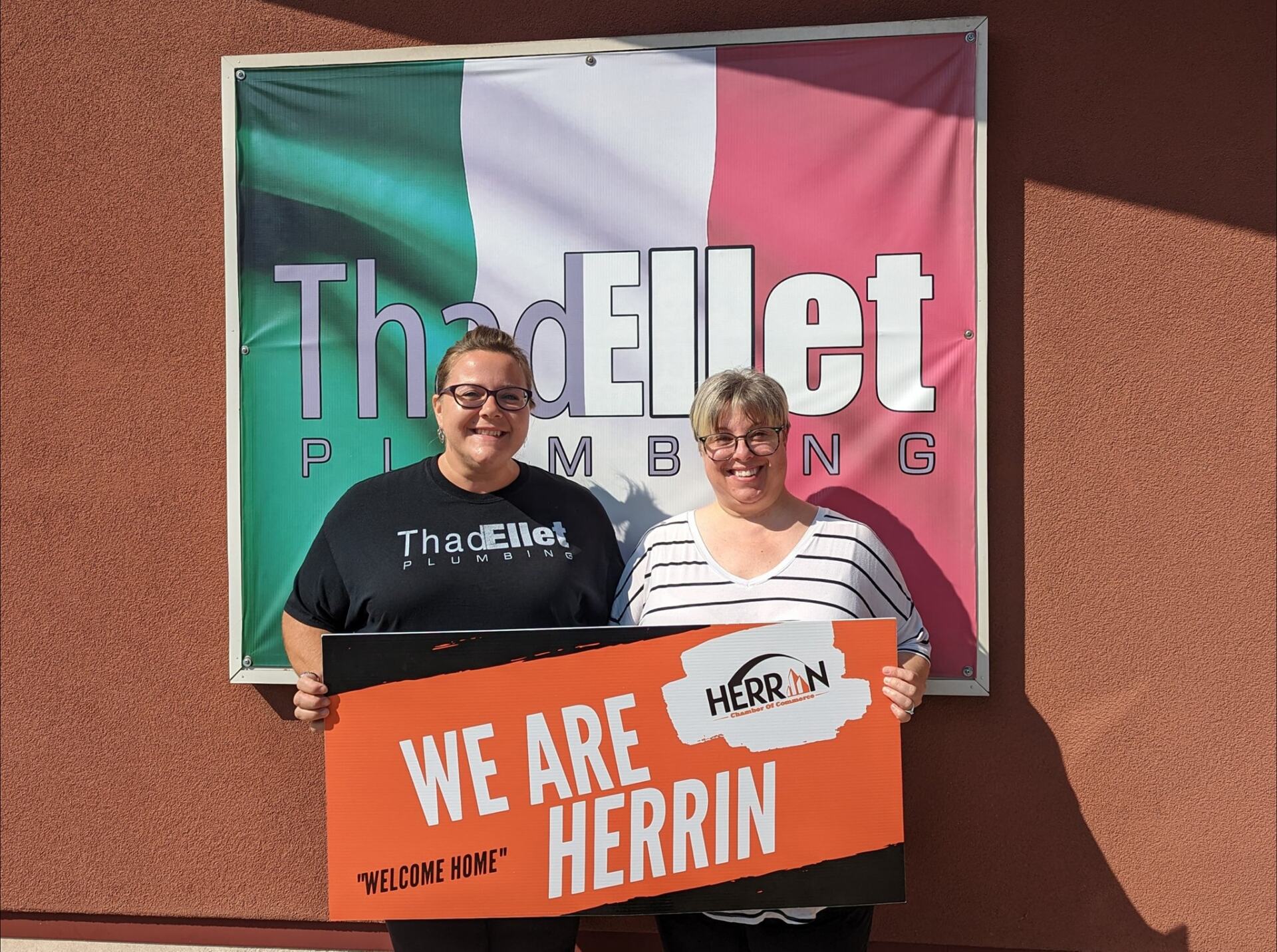 Two people holding a sign that says we are herrin