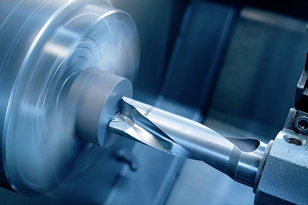 A machine is cutting a piece of metal on a lathe.