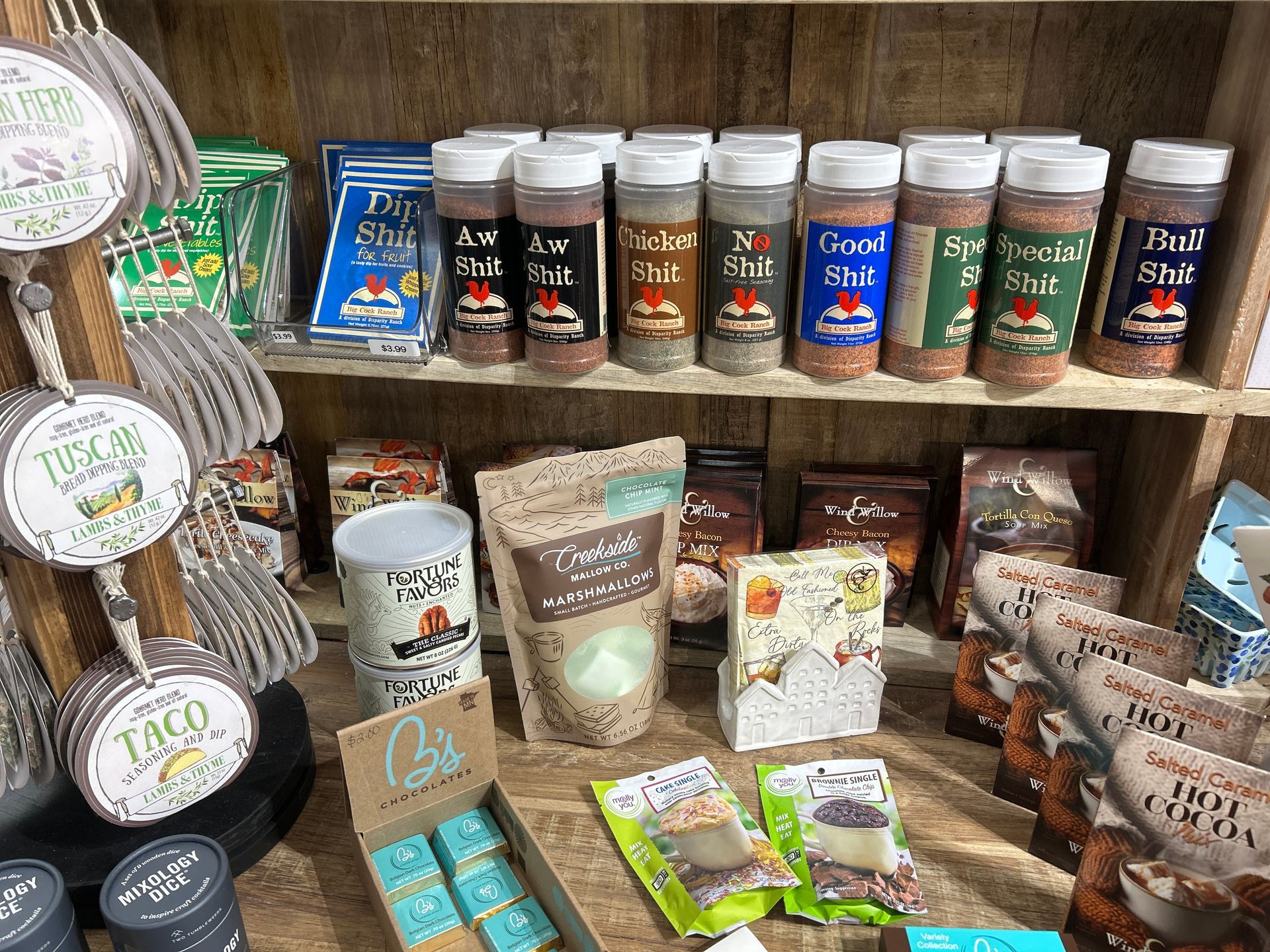 Assorted packaged teas and tea accessories displayed on wooden shelves in a shop.