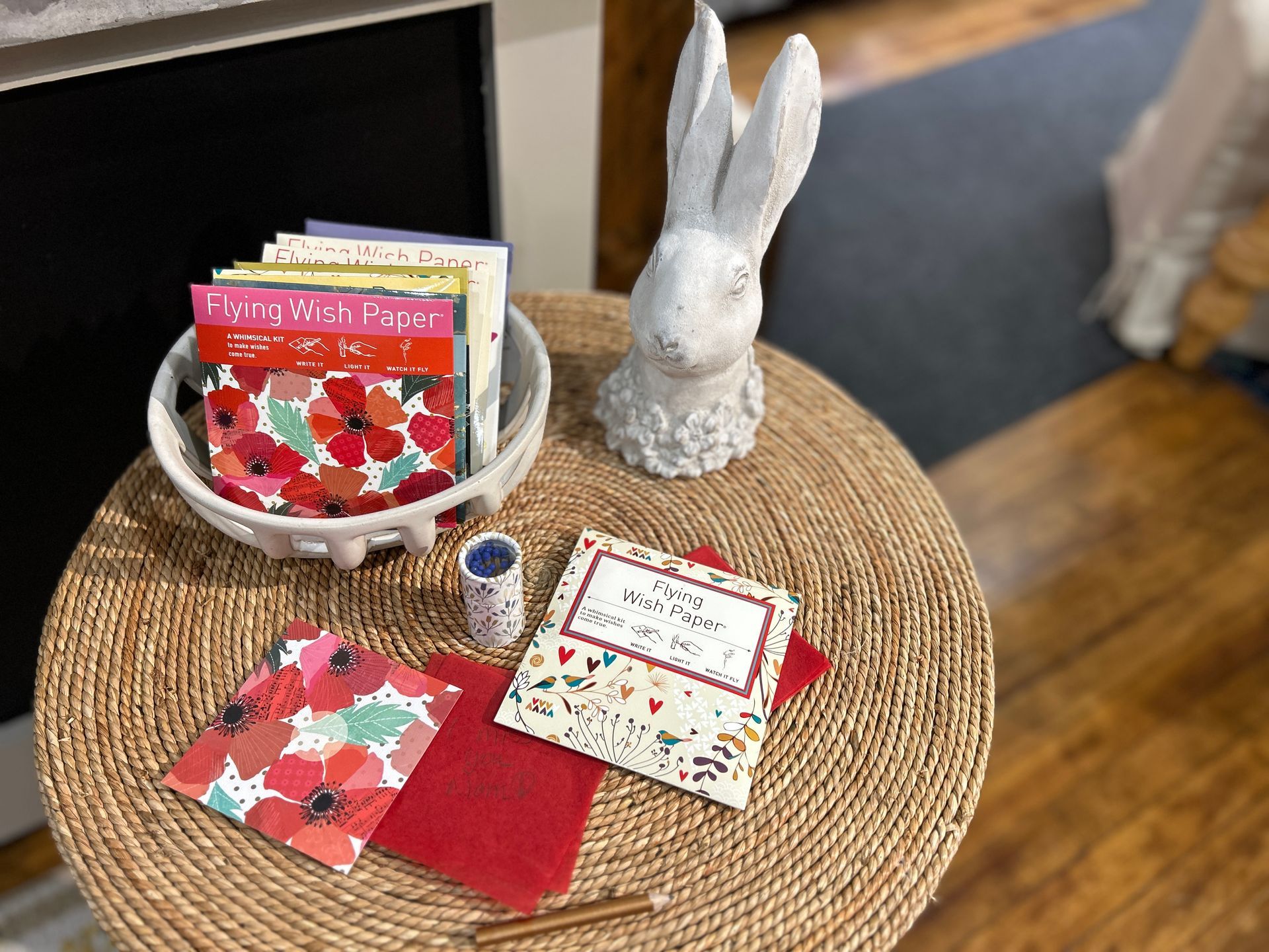 Easter display with white bunny figurine, strawberry-themed cards, and a woven placemat on a table