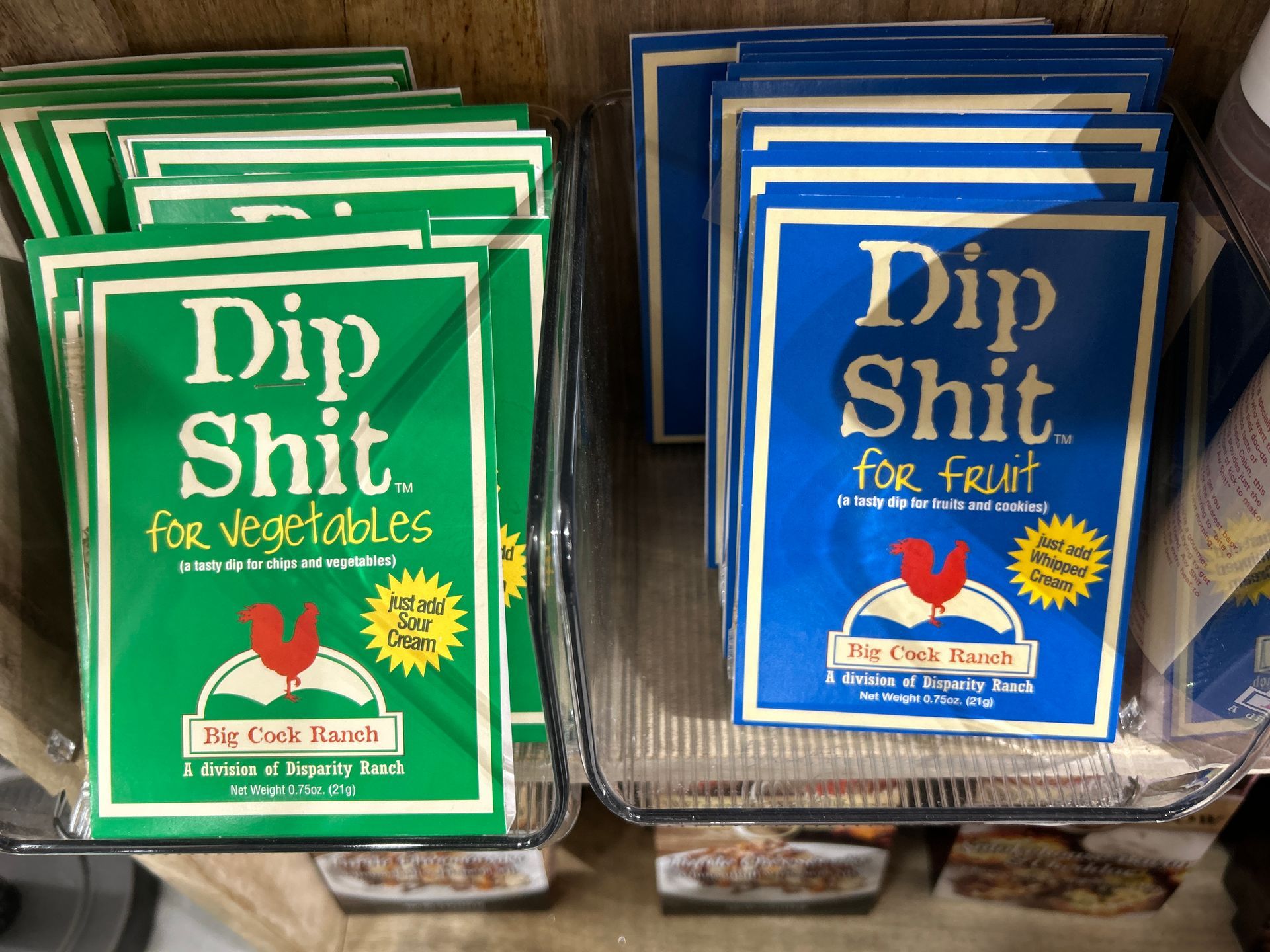 Green and blue packages of Dip Shit for vegetables displayed on a shelf