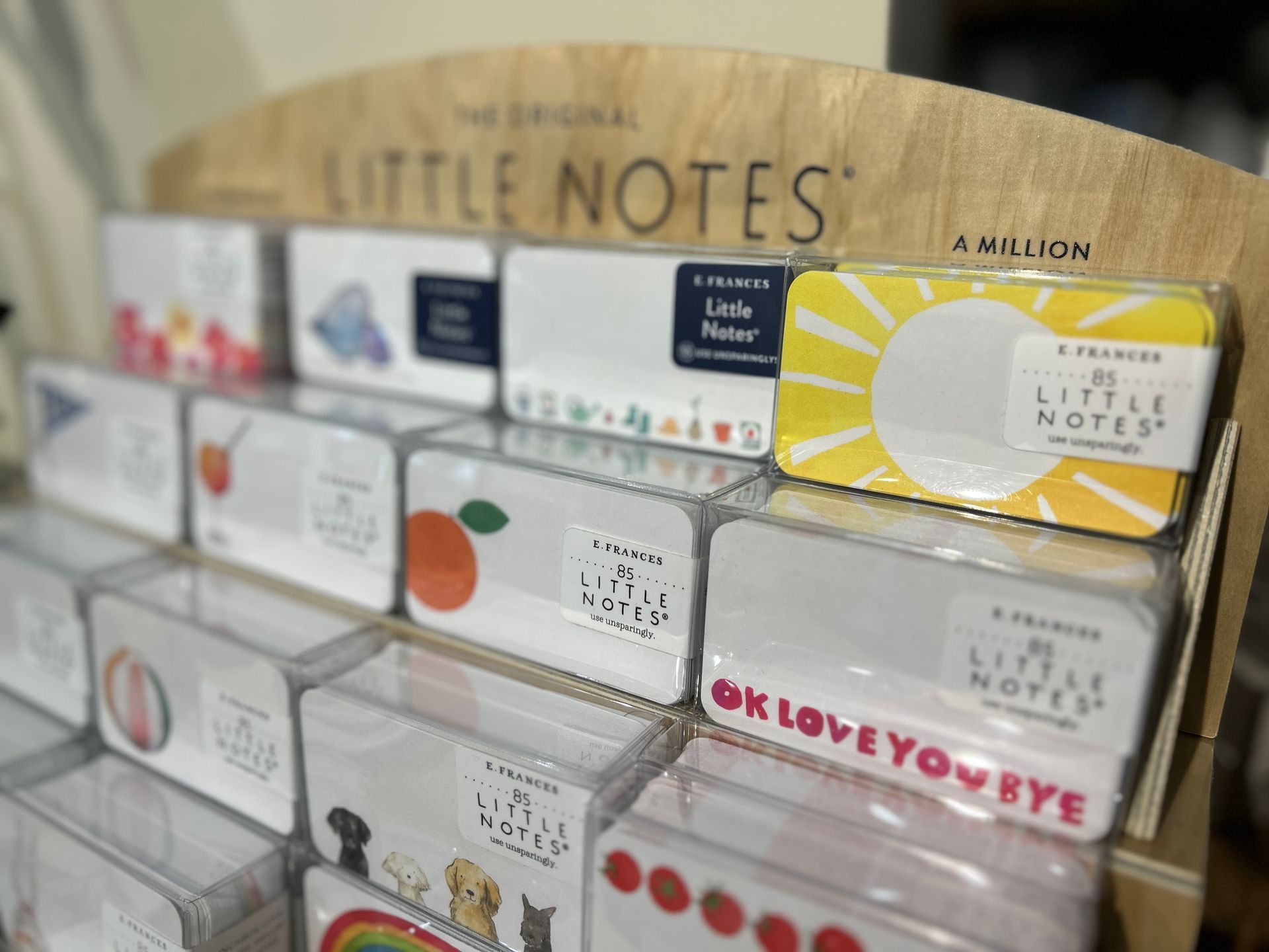 Shelf of colorful “Little Notes” sticky note boxes in a stationery store display