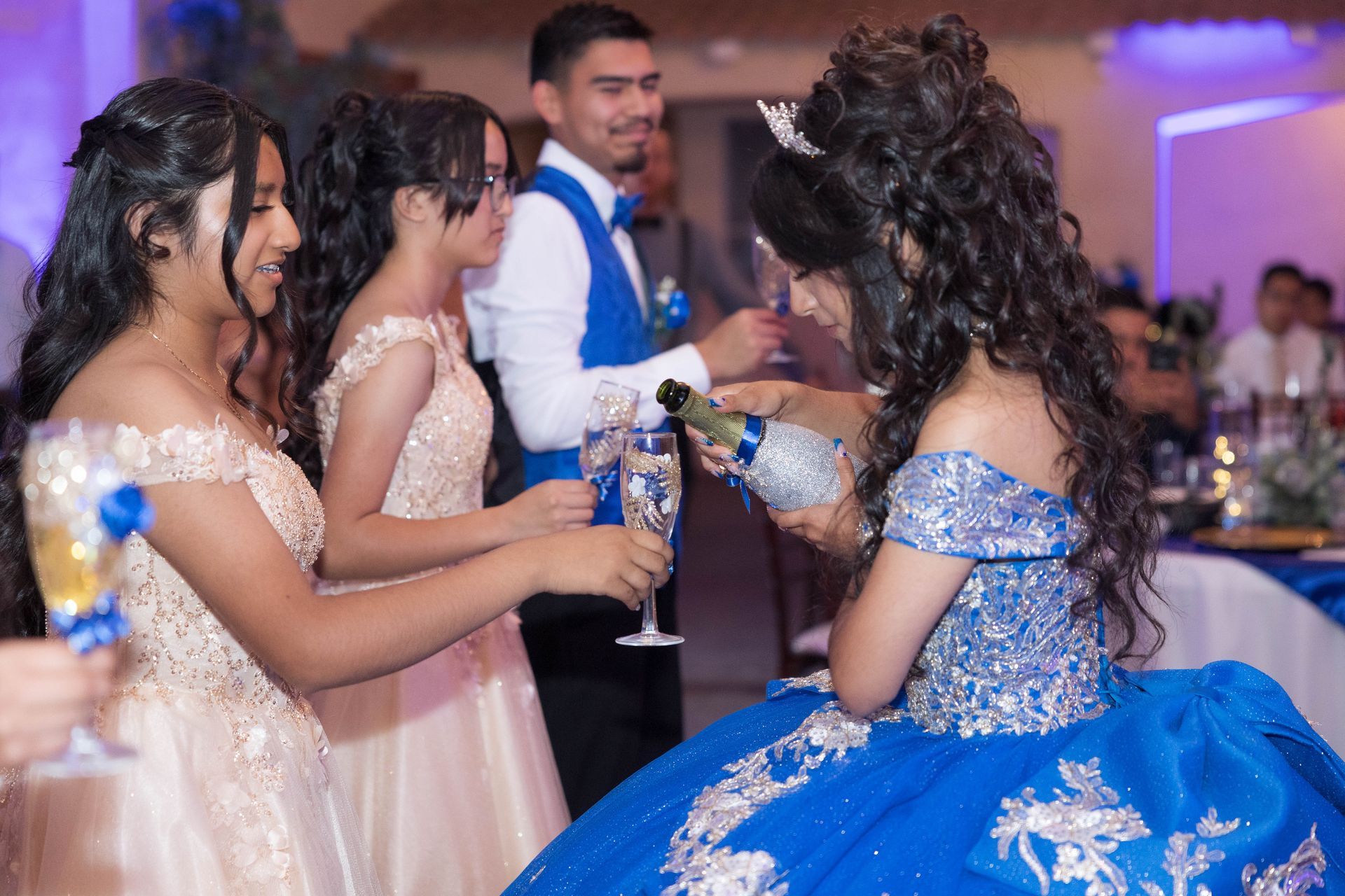 Guests in formal dresses chatting at a reception table in a decorated banquet hall