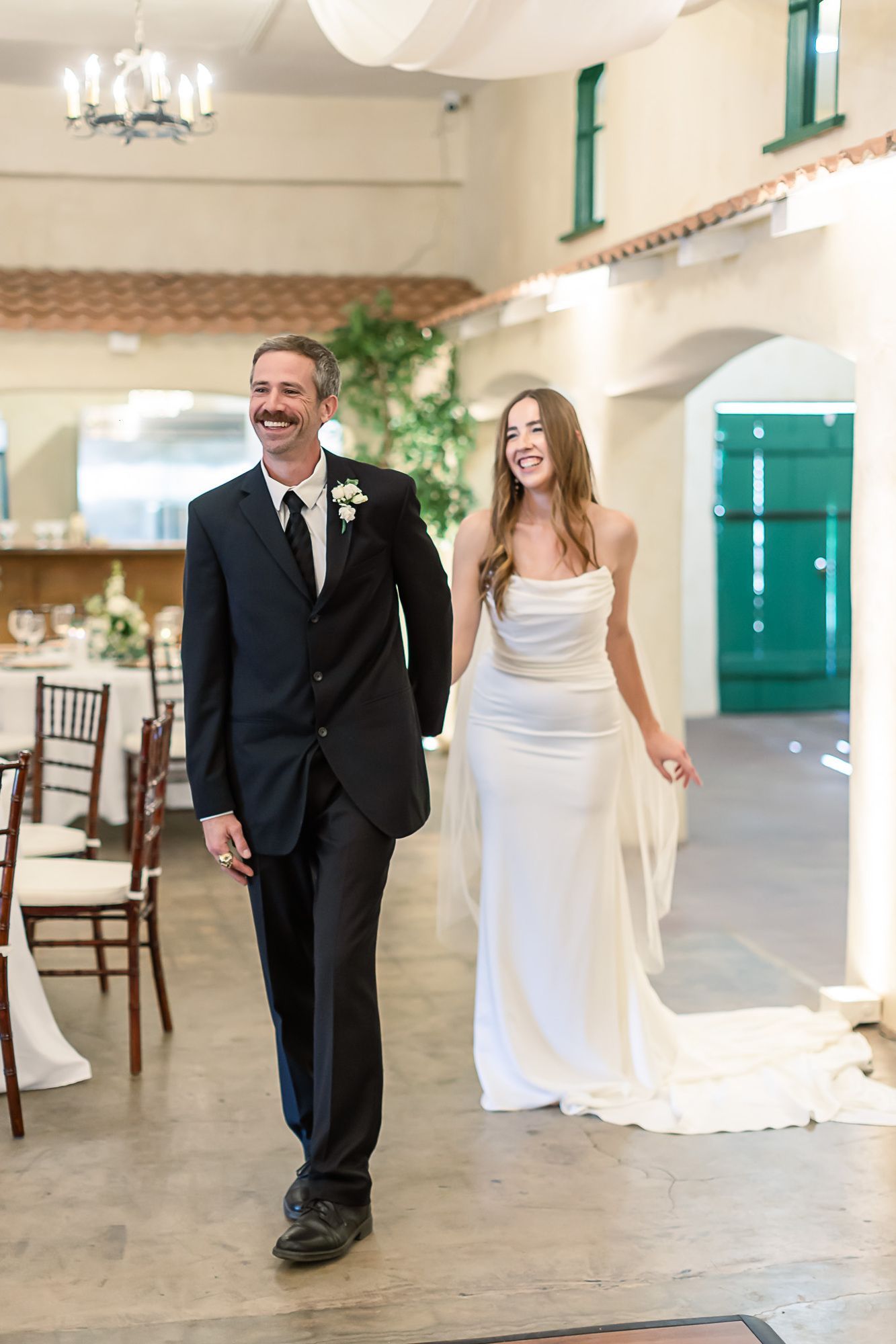 Bride and groom walking together in a bright wedding hall