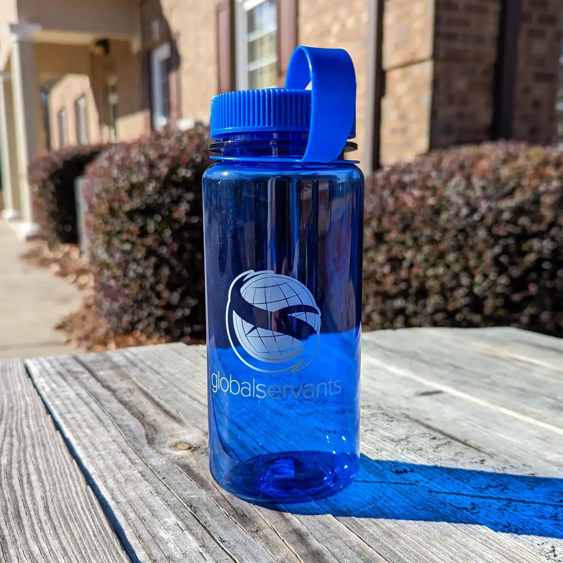 A blue water bottle is sitting on a wooden table.