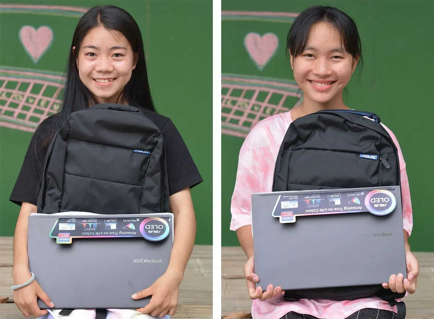 Two girls are holding a laptop and a backpack.