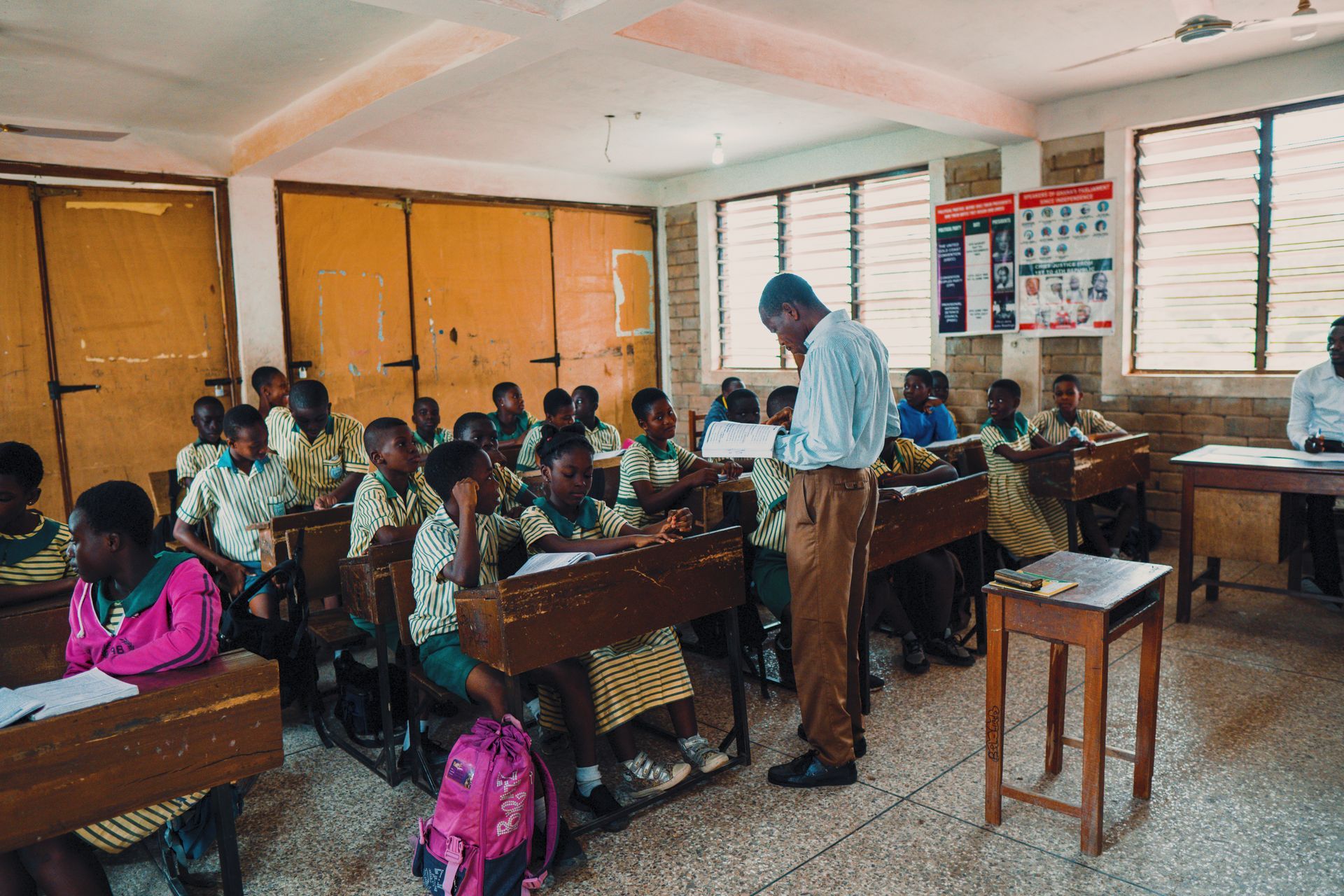 A teacher is standing in front of a classroom full of children.