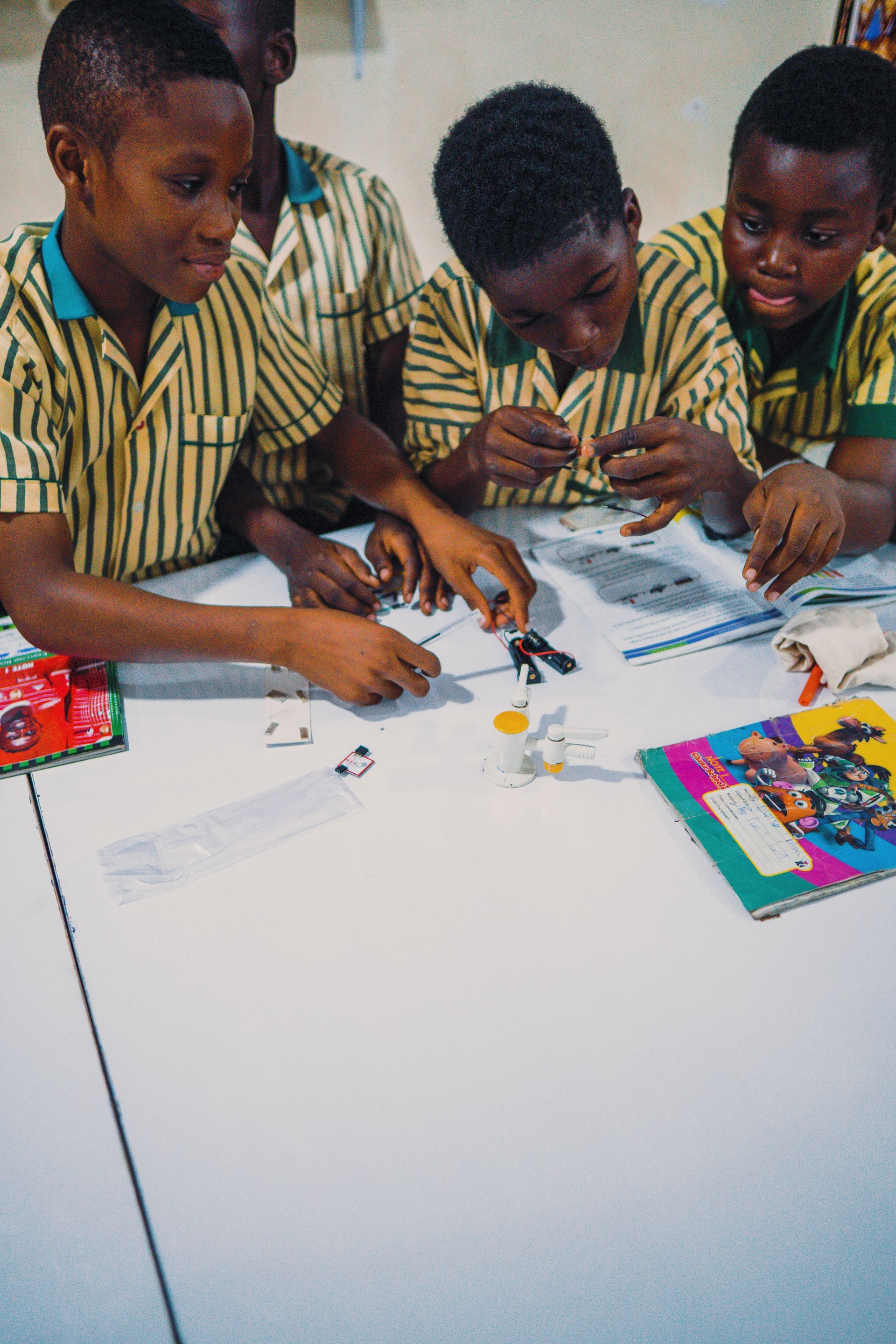A group of children are sitting around a table playing with toys