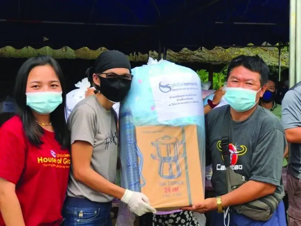 A group of people wearing face masks are holding a large box.