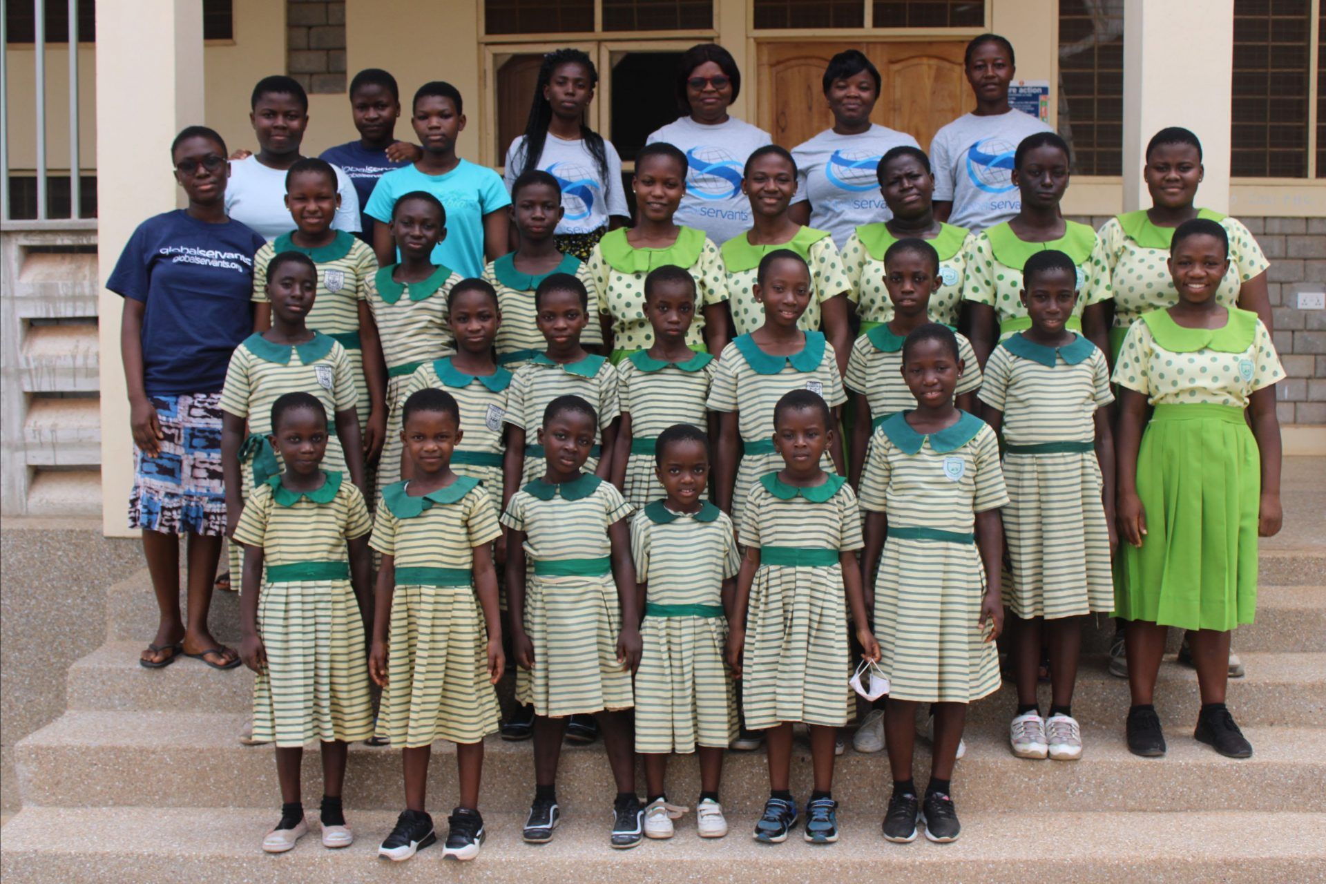 A group of children posing for a picture in front of a building