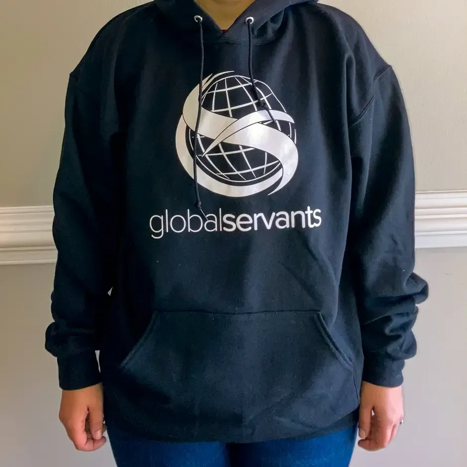 A person wearing a black hoodie that says globalservants