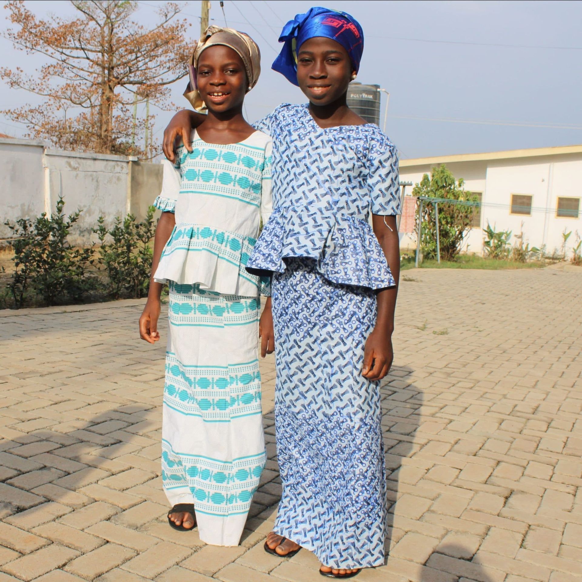 Two girls in blue and white dresses are posing for a picture