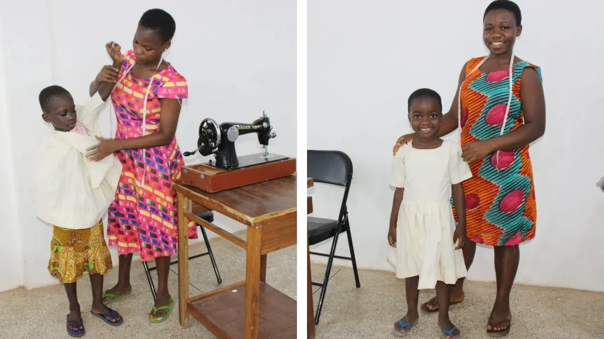 A woman is standing next to a little girl in front of a sewing machine.