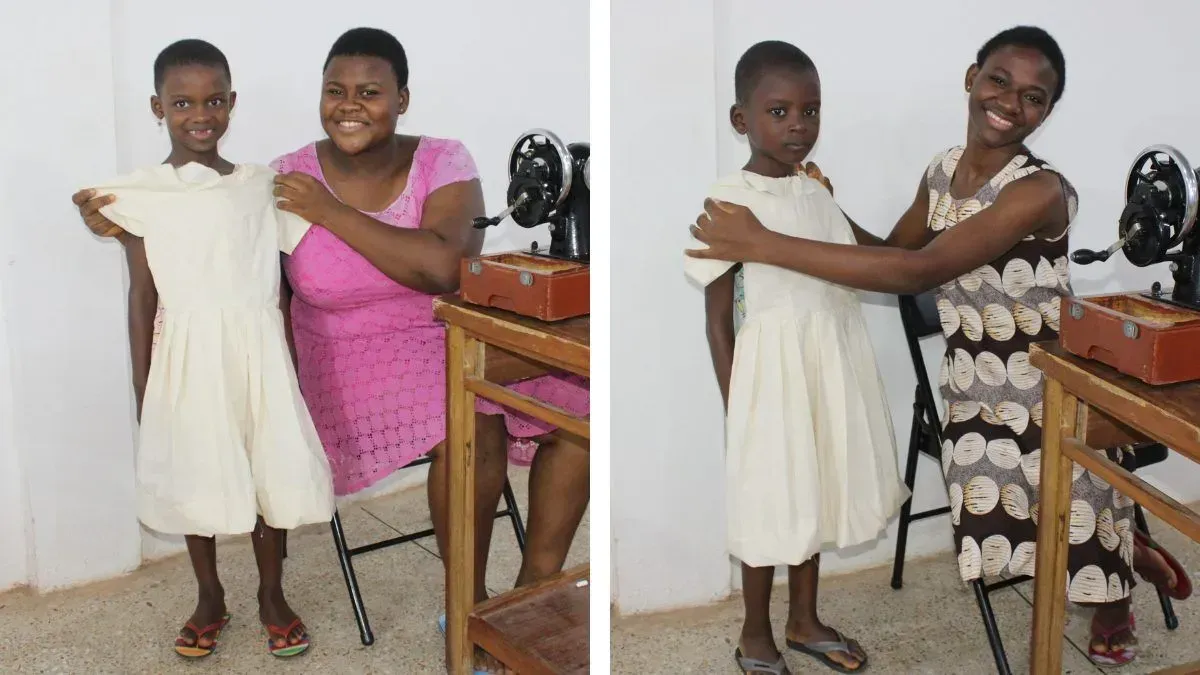 Two women are standing next to each other in front of a sewing machine.
