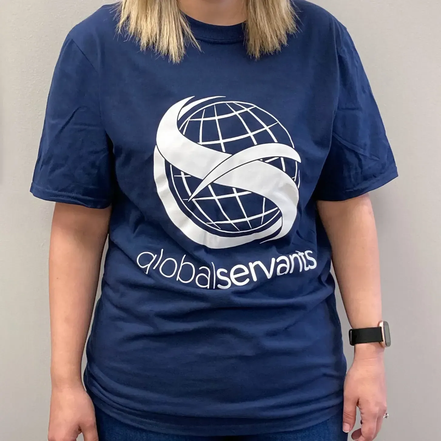 A woman wearing a blue shirt that says globalservants