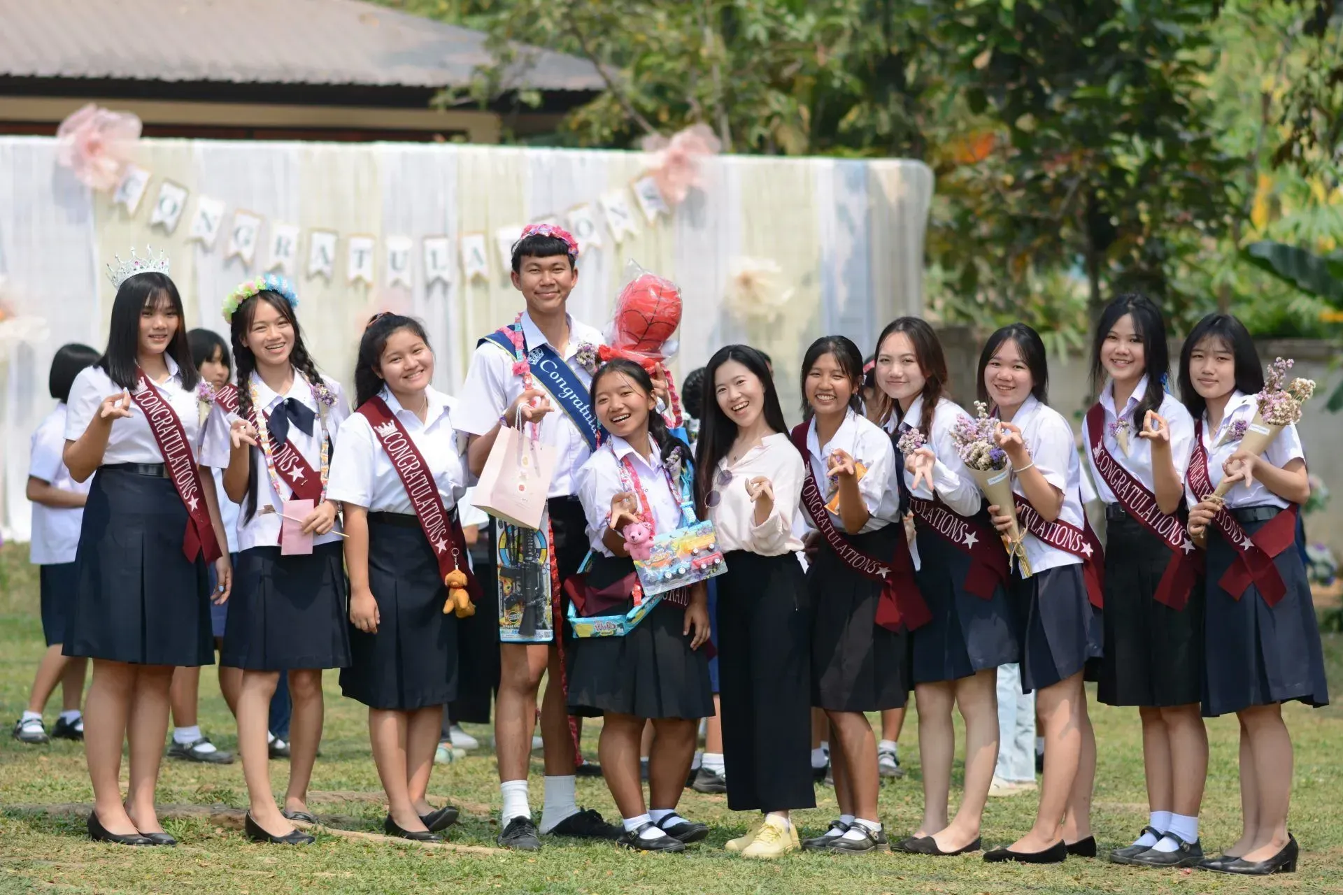 A group of young people are posing for a picture in a field.