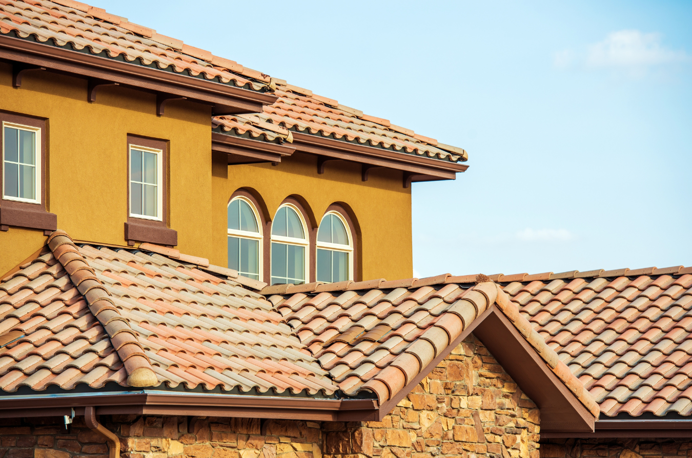 the roof of a house with a brown roof and a blue sky in the background .