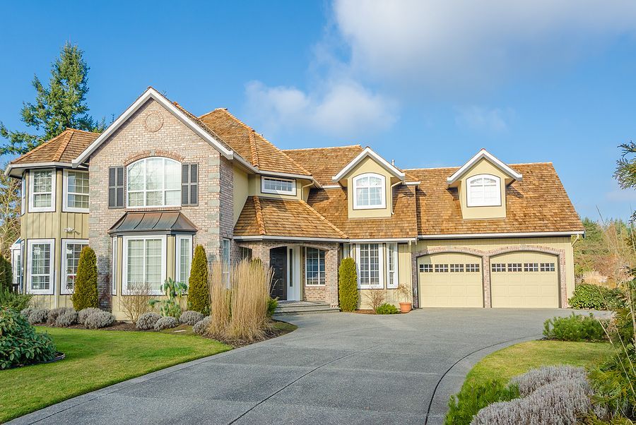 A large house with a paved driveway installed by Cambridge Resin Driveways